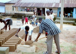 Dorps chief helpt mee met  maken van blokken